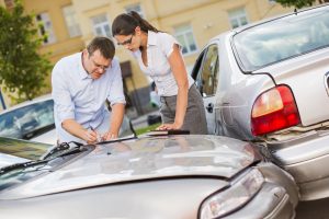 Drivers fill out an accident statement report after having a parking lot accident.